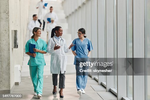 Happy female doctors talking on the move in a hospital. Happy female doctors talking on the move in a hospital.