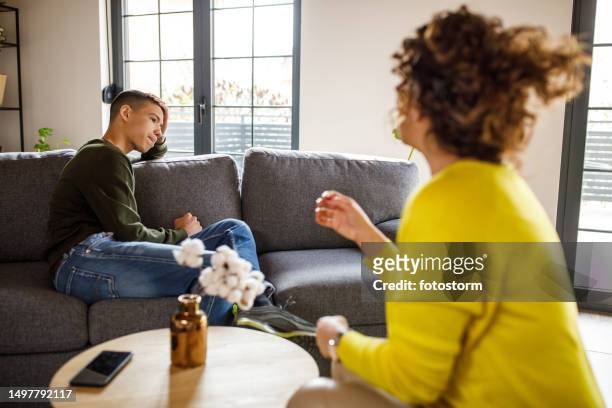 insecure teenage boy having a sincere conversation with his reassuring mother - depressed mother stockfoto's en -beelden