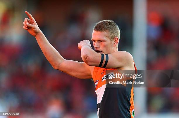 Adam Treloar of the Giants kisses his black arm band after kicking a goal during the round 19 AFL match between the Greater Western Sydney Giants and...