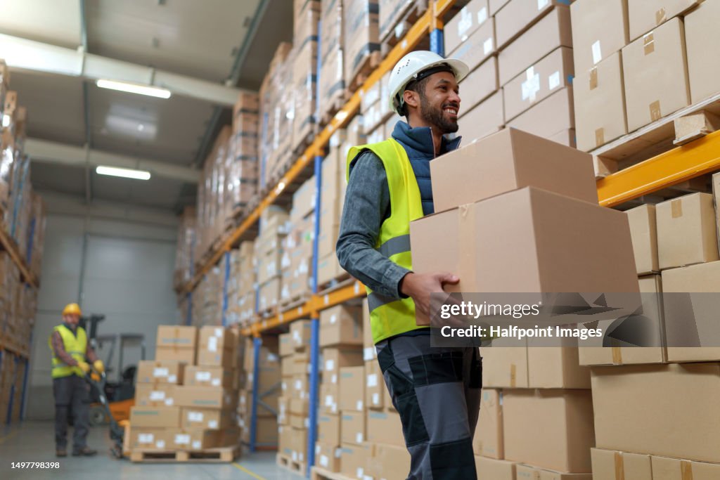 Multiracial warehouseman receiving and processing warehouse stock products