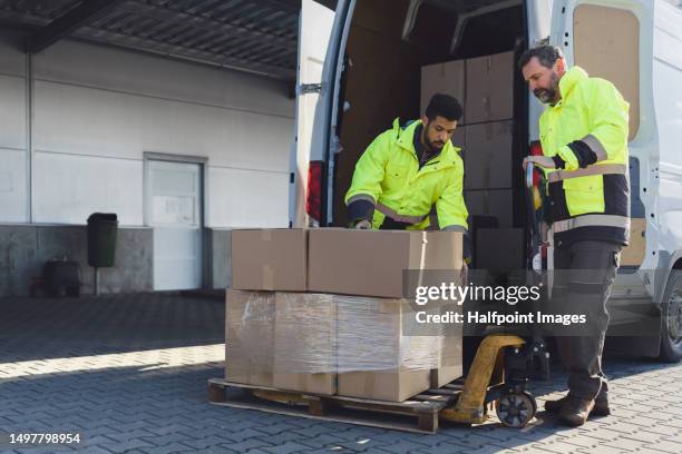 warehouse workers loading vehicle with goods on loading dock. - ware house worker forklift stock pictures, royalty-free photos & images
