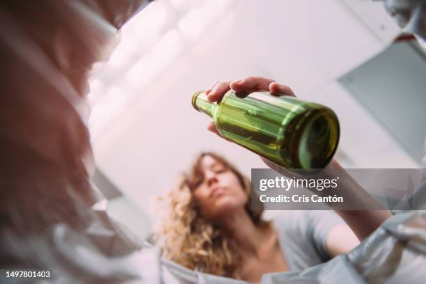 woman throwing beer bottle into glass recycling bin - sopor bildbanksfoton och bilder