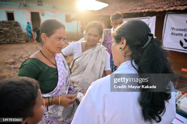 the doctor explaining medicine dosage and giving out medicines to village women during rural health care camp. - primary care stock pictures, royalty-free photos & images