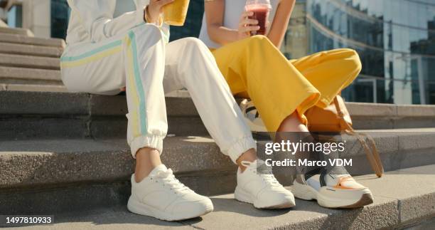 amigos, pernas e sapatos nos degraus da cidade para união, viagens e férias urbanas com bebidas, smoothie e bebida, casal, pessoas e escadas da cidade para a moda, roupas de street style descoladas e modernas - sapato - fotografias e filmes do acervo