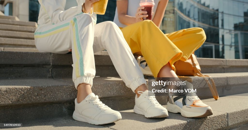 Friends, legs and shoes on city steps for bonding, travel and urban break with drinks, smoothie and beverage, Couple, people and town stairs for fashion, cool and trendy street style clothing