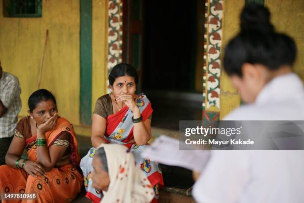 assistant doctor taking medical history of a rural woman during a home visit as part of a rural health care camp. - primary care stock pictures, royalty-free photos & images
