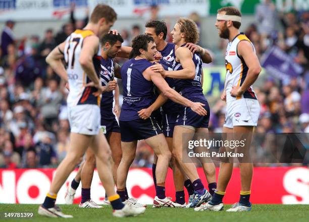 The Dockers celebrate a goal as Adam Selwood and Will Schofield look on during the round 19 AFL match between the Fremantle Dockers and the West...