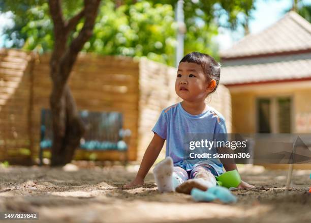 happy weekend activity asian toddler enjoy playing sandbox on the playground at public park - 2 boys 1 sandbox stock pictures, royalty-free photos & images