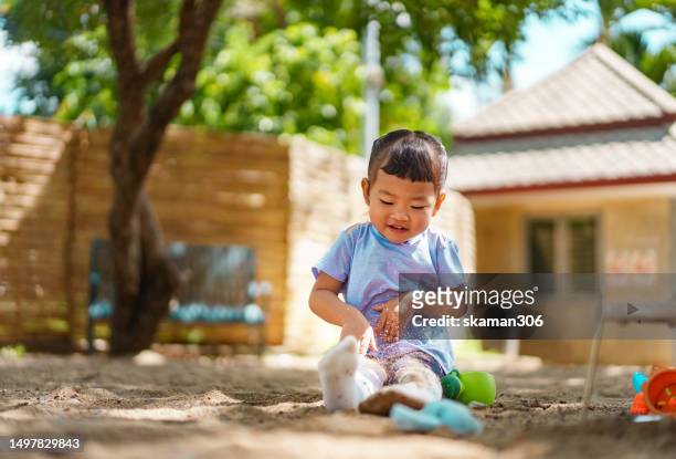 happy weekend activity asian toddler enjoy playing sandbox on the playground at public park - 2 girls 1 sandbox stock pictures, royalty-free photos & images