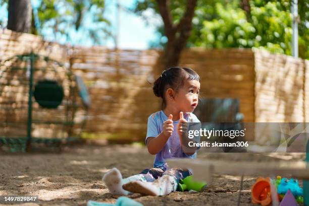 happy weekend activity asian toddler enjoy playing sandbox on the playground at public park - 2 boys 1 sandbox stock pictures, royalty-free photos & images