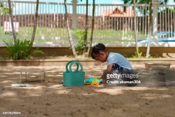 happy weekend activity asian toddler enjoy playing sandbox on the playground at public park - 2 boys 1 sandbox stock pictures, royalty-free photos & images
