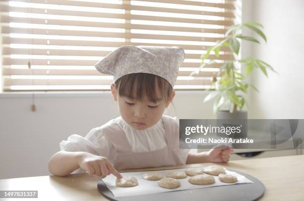 girl making cookies - ボウル stock pictures, royalty-free photos & images