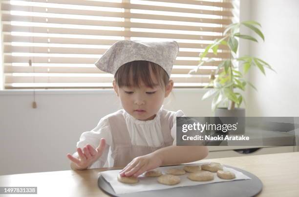 girl making cookies - 時間 fotografías e imágenes de stock