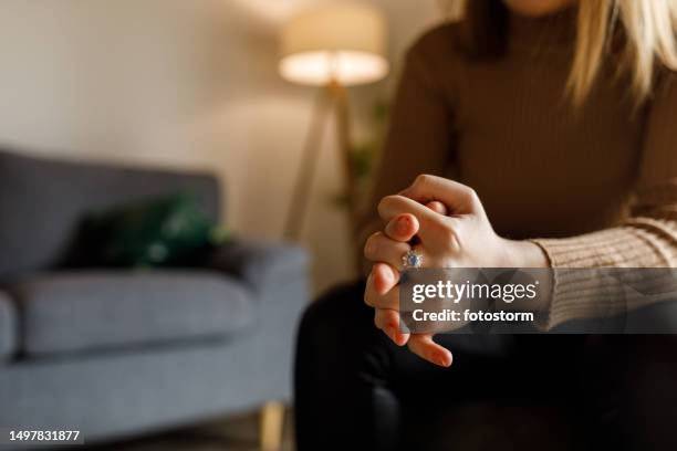 young woman anxiously cracking her knuckles, struggling with negative emotions - knuckles stock pictures, royalty-free photos & images