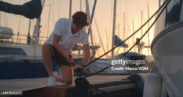 boat, sailing and man in harbor with ropes, cable and tie knot for boating lesson, learning and leisure sport. travel, sunset and man  on desk for cruise, luxury sailboat and adventure - sailing ship night stock pictures, royalty-free photos & images