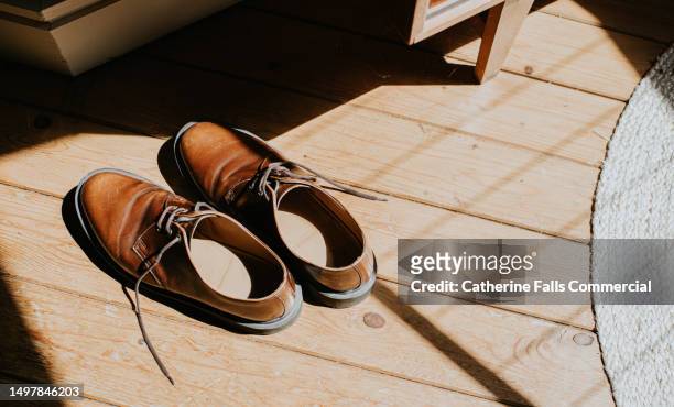 top down, simple, conceptual image of a pair of brown brogues, illuminated by sunlight - leather stitching stock pictures, royalty-free photos & images