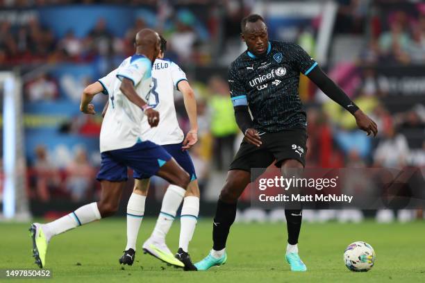 Usain Bolt of World XI takes on Asa Butterfield and Mo Farah of England during Soccer Aid for Unicef 2023 at Old Trafford on June 11, 2023 in...