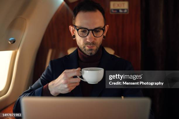 ceo businessman enjoys his cup of coffee in first class on a private plane - premium acess stock-fotos und bilder