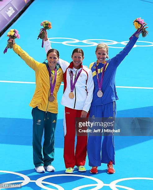 Silver medalist Lisa Norden of Sweden, Gold medalist Nicola Spirig of Switzerland, and Bronze medalist Erin Densham of Australia pose with their...