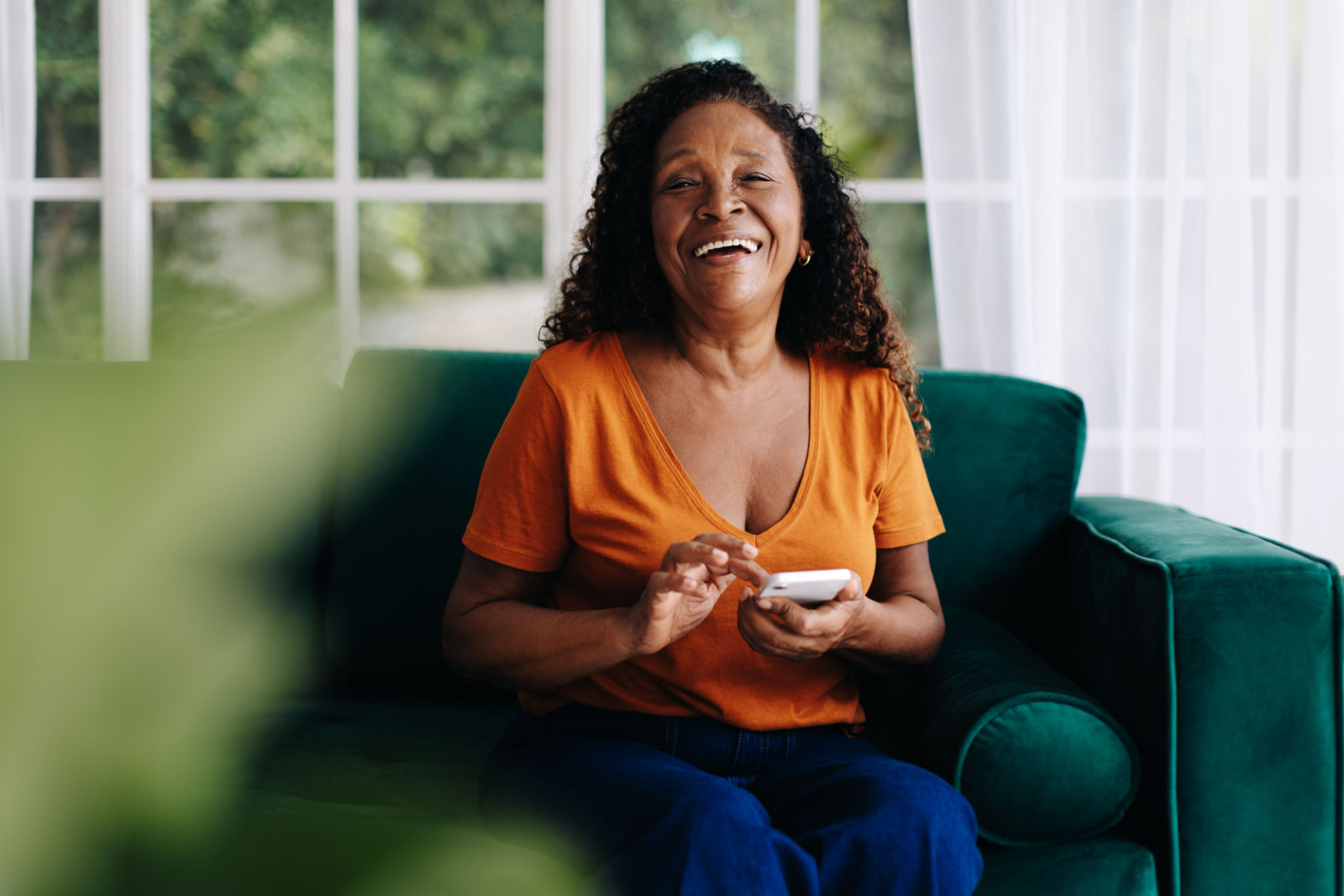 Happy black woman enjoying using mobile apps for seniors on her smartphone Happy black woman enjoying using mobile apps for seniors on her smartphone