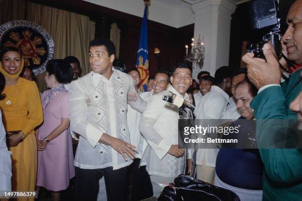 World heavyweight boxing champion Muhammad Ali pulls a face as his friend Veronic Porché looks on at Malacanang Palace in Manila, Philippines,...