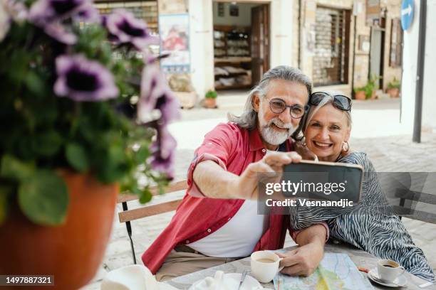 reifes paar als tourist, genießt lokalen kaffee im café in der seitenstraße, zypern - limassol stock-fotos und bilder
