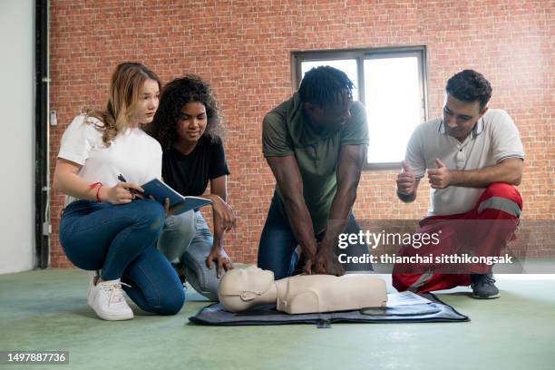 image of instructor teaching trainee practicing chest compressions on a cpr dummy. - emergency planning ストックフォトと画像