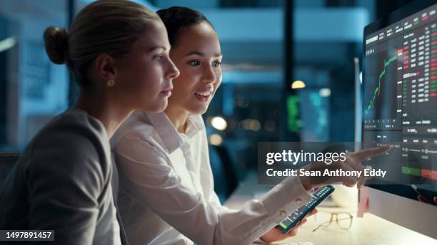 business, finance and economy professionals looking at the financial income and expense of the company on a computer screen. female traders working and collaborating overtime to meet a deadline - traders stock pictures, royalty-free photos & images
