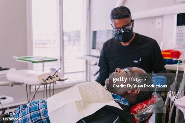 black man at routine dental appointment - a male dentist stock pictures, royalty-free photos & images