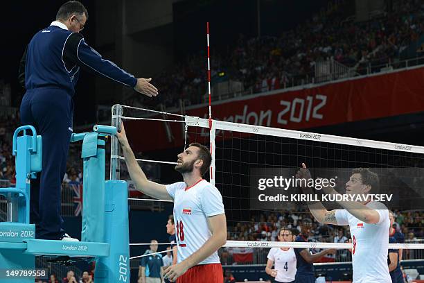 Poland's Marcin Mozdzonek and Zbigniew Bartman react speak to the umpire during the Men's preliminary pool A volleyball match between Britain and...