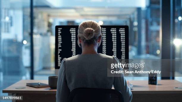 プログラマーやサイバーセキュリティの従業員がオフィスで深夜に残業している様子をバックビュー。熟練した女性のweb専門家は、彼女の職場で夕方にコンピュータにバックエンドアルゴリ� - one person time ストックフォトと画像