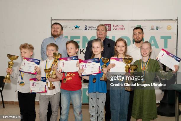 Winners among boys and girls of the Ukrainian Chess Championship in the classical game hold their trophies, diplomas, and medals during award...