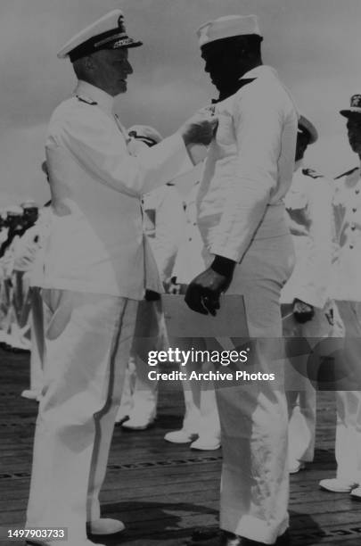 Admiral Chester W. Nimitz pins the Navy Cross onto Doris "Dorie" Miller , USS Enterprise , Pearl Harbor, May 27, 1942.