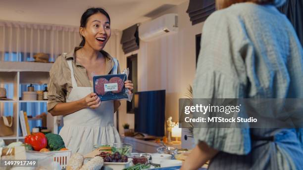 young asian women friends preparing plant-based meal and cooking salad in kitchen table at home at night. lifestyle healthy food eating enjoying natural life and plant-based diet. - meat product stock pictures, royalty-free photos & images