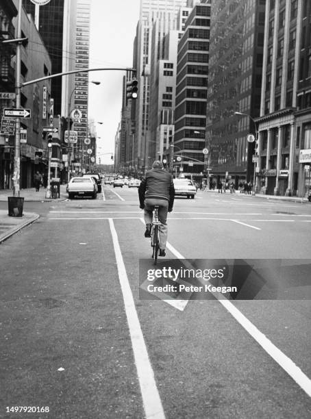 Cyclist riding in the cycle lane on Sixth Avenue in the borough of Manhattan, New York City, New York, 1979.