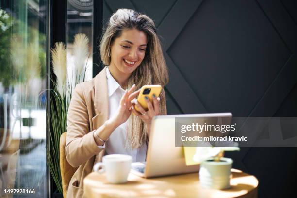 schöne junge frau, die im café sitzt. - true luxury stock-fotos und bilder