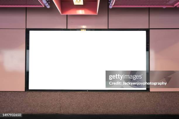 a subway station wall is covered with blank billboard advertising banner media. - subway platform poster stock pictures, royalty-free photos & images