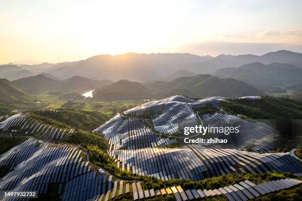 hilltop solar power plant reflecting sunset sunlight - responsabilidad social fotografías e imágenes de stock
