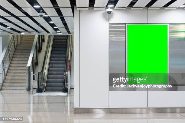 a subway station wall is covered with green blank billboard advertising banner media. - airport stairs stock pictures, royalty-free photos & images