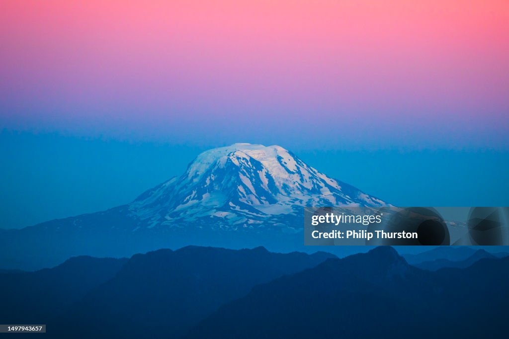 Mount Rainier mit pastellfarbenen Farbbändern in der Abenddämmerung mit Schnee auf der Spitze