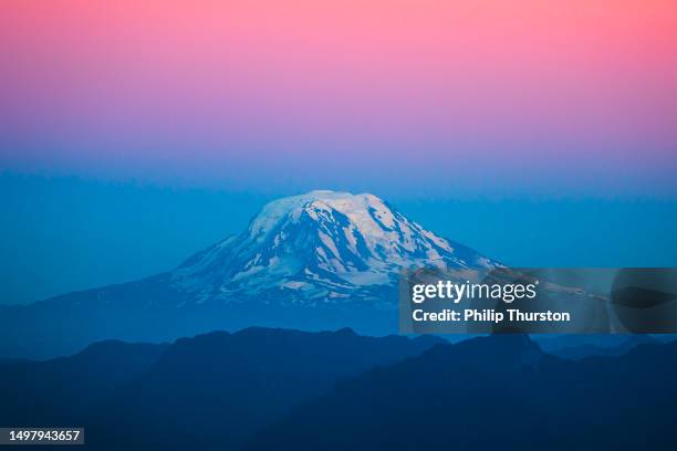 mount rainier with pastel bands of colour at dusk with snow on top - monte rainier imagens e fotografias de stock
