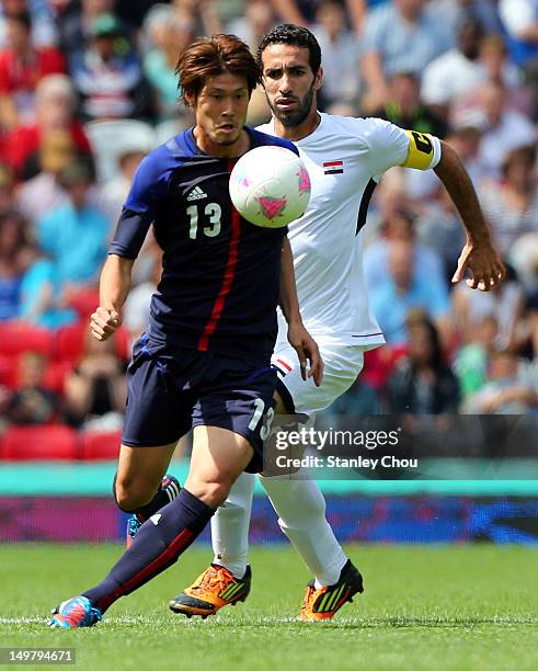 Daisuke Suzuki of Japan is pursuit by Mohamed Aboutreika of Egypt during the Men's Football Quarter Final match between Japan and Egypt, on Day 8 of...