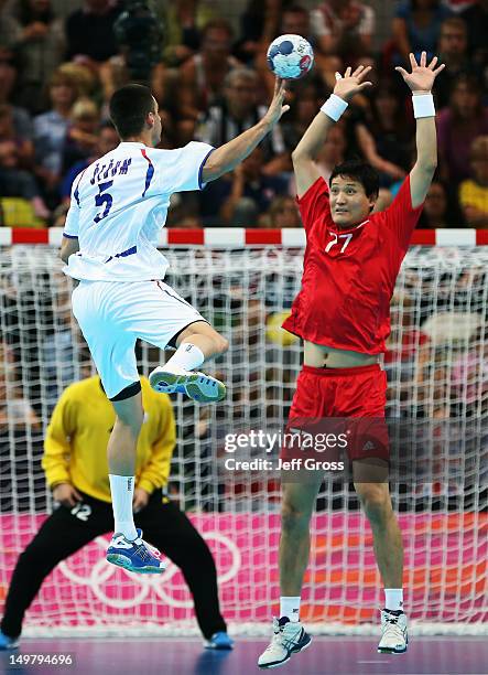 Zarko Sesum of Serbia passes the ball while defended by Kyung Shin Yoon of Korea during the Men's Preliminaries Group B match between Korea and...