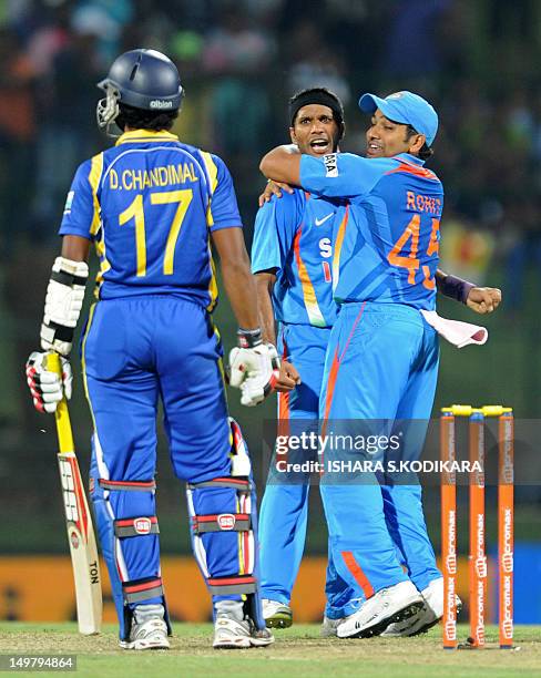 Indian cricketer Ashok Dinda celebrates with teammate Rohit Sharma after dismissing Sri Lankan cricketer Dinesh Chandimal during the fifth and final...