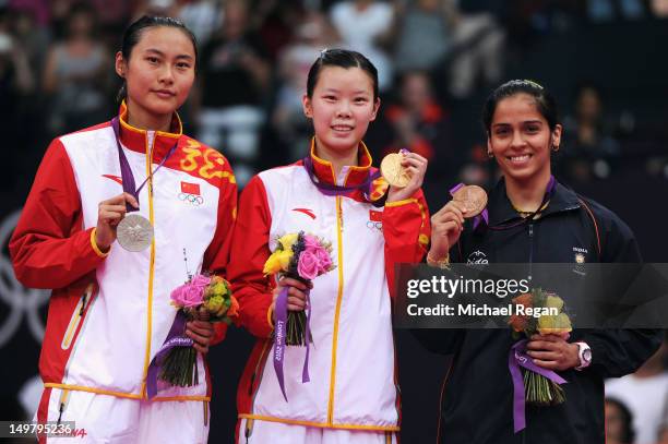 Xuerui Li of China celebrates on the podium with her Gold medal, Yihan Wang of China the Silver and Saina Nehwal of India the Bronze following the...