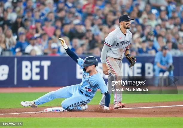 Cavan Biggio of Toronto Blue Jays slides into third base in front of Royce Lewis of Minnesota Twins during the fifth inning in their MLB game at the...
