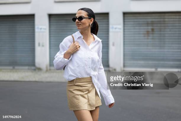 Anna Winter wears white blouse Filippa K, beige skirt The Frankie shop, white socks, black shoes Prada, sunglasses, bag Louis Vuitton on June 12,...