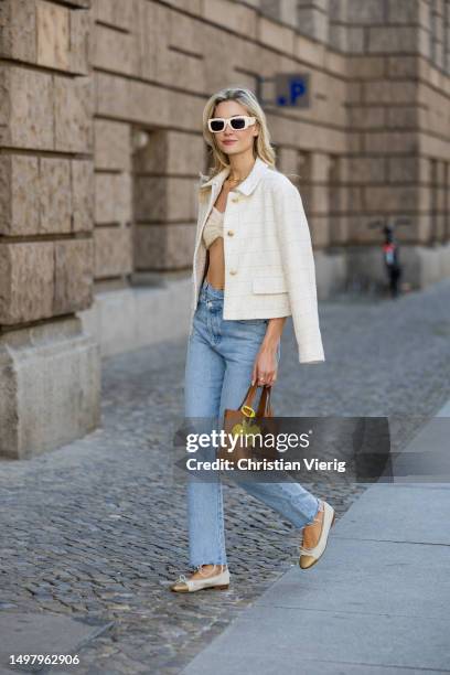 Mandy Bork wears denim jeans Agolde, white jacket & cropped top Zara, sunglasses Linda Farrow, necklace Van Cleef & Arpels, shoes Chanel, brown bag...