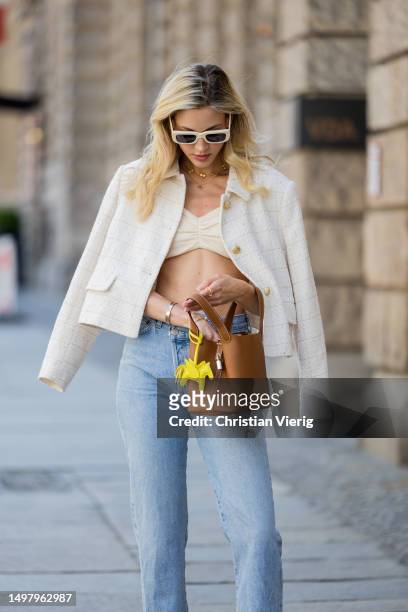 Mandy Bork wears denim jeans Agolde, white jacket & cropped top Zara, sunglasses Linda Farrow, necklace Van Cleef & Arpels, shoes Chanel, brown bag...