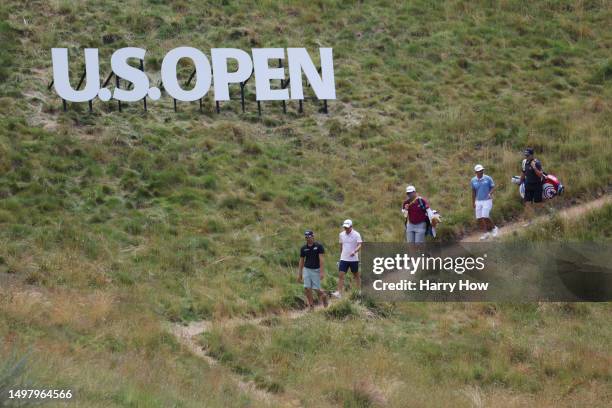 Min Woo Lee of Australia, Collin Morikawa of the United States and Kurt Kitayama of The United States walk on the fourth hole during a practice round...